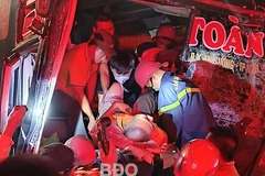 Cứu tài xế xe khách bị mắc kẹt trong cabin ra ngoài. (Ảnh: CA cung cấp)