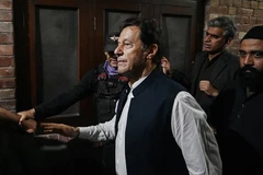 Cựu Thủ tướng Pakistan Imran Khan (phía trước) rời khỏi toà án ở Lahore, ngày 17/3/2023. (Ảnh: AFP/TTXVN) 