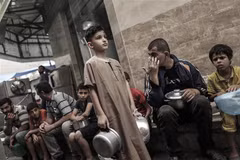 Người dân Palestine xếp hàng chờ nhận thực phẩm cứu trợ tại Dải Gaza. (Ảnh: AFP/TTXVN)