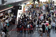 Hành khách tại sân bay Haneda ở thủ đô Tokyo, Nhật Bản. (Ảnh: AFP/ TTXVN)