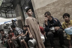 Người dân Palestine xếp hàng chờ nhận thực phẩm cứu trợ tại Dải Gaza. (Ảnh: AFP/TTXVN)