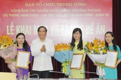 Phó Trưởng ban Thường trực Ban Tổ chức Trung ương Nguyễn Thanh Bình trao Quyết định bổ nhiệm cho các cán bộ bảo vệ tốt đề án. (Ảnh: Văn Điệp/TTXVN)