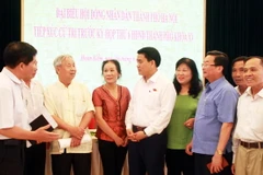 Chủ tịch Ủy ban Nhân dân thành phố Hà Nội Nguyễn Đức Chung cùng các cử tri Quận Hoàn Kiếm. (Ảnh: Văn Cảnh/TTXVN)