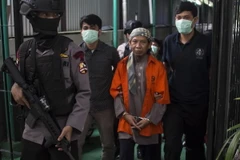 Cảnh sát vũ trang Indonesia áp giải giáo sỹ Hồi giáo cực đoan Aman Abdurrahman (áo cam) tới Tòa án Nam Jakarta. (Nguồn: AFP/TTXVN)