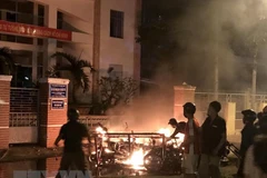 Một số đối tượng quá khích lôi xe máy từ trong Sở Kế hoạch và Đầu tư tỉnh Bình Thuận ra đốt phá. (Ảnh: Nguyễn Thanh/TTXVN)