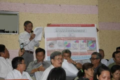 Cử tri phân tích bản đồ để phản ánh, kiến nghị các nội dung liên quan đến dự án Khu đô thị mới Thủ Thiêm. (Ảnh: Tiến Lực/TTXVN)