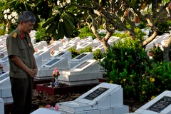 Chú Trần Tường Huấn, cựu học sinh trường Chu Văn An bên một trong những nấm mộ liệt sỹ có thể là liệt sỹ Đặng Trần Cảnh.