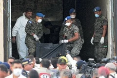 Cảnh sát thu thập các xác chết trong vụ cháy ở Honduras (Nguồn: AFP)