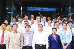 Thường trực Ban Bí thư Lê Hồng Anh với các đại biểu tại Ngân hàng liên doanh Lào-Việt. (Ảnh: Thống Nhất/TTXVN)