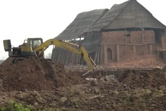 Các lò gạch ngang nhiên dùng máy xúc lấy đất khu vực đê sông Đáy. (Ảnh: Nguyễn Trường/Vietnam+)