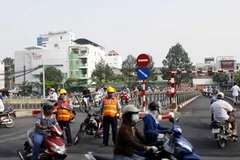 Người dân lưu thông qua cầu tạm gần cầu Bông. (Ảnh: Hoàng Hải/Vietnam+) 