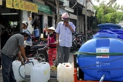 Người dân phải đi mua nước sạch về dùng. (Ảnh minh họa: Hoàng Hải/TTXVN) 