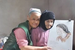 Họa sĩ Đặng Ái Việt bên Mẹ Việt Nam anh hùng và tác phẩm của bà. (Nguồn: Vietnam+)