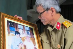 Nhà văn, nhà báo Nguyễn Thế Tường với bức ảnh quý ghi lại khoảnh khắc đáng nhớ bên Đại tướng. (Ảnh: Võ Thành/Vietnam+)
