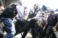 Cảnh sát đưa thi thể nạn nhân vụ cháy trung tâm cai nghiện đến nhà xác (Nguồn: Reuters)