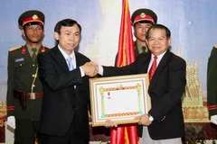 Ông Soukan Mahalath trao tặng Huân chương cho ông Trần Văn Thực. (Ảnh: Hoàng Chương/Vietnam+)