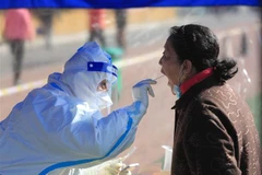  Nhân viên y tế lấy mẫu xét nghiệm COVID-19 cho người dân tại Thẩm Dương, tỉnh Liêu Ninh, Trung Quốc, ngày 17/3/2022. (Ảnh: THX/TTXVN)