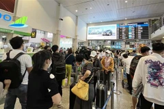 Hành khách xếp hàng làm thủ tục tại Sân bay Tân Sơn Nhất. (Ảnh: Tiến Lực/TTXVN)