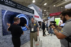 Một nhân viên trả lời phỏng vấn trước TV OLED 97 inch của LG Electronics trưng bày tại Hội chợ Thiết kế & Lắp đặt Điện tử Tiêu dùng (CEDIA) 2022 ở Dallas, Texas, Mỹ. (Nguồn: Yonhap)