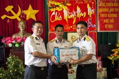 Phó Chủ nhiệm Chính trị Vùng 2 Hải quân, Đại tá Vũ Duy Lưu tặng quà Tết của Đảng uỷ - Tiểu đoàn DK1 cho cán bộ, chiến sỹ nhà giàn DK1/9. (Ảnh: Hồng Đạt/TTXVN)