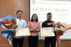 Bà Nguyễn Thị Thu Hường, Giám đốc Sở Nội vụ Đắk Nông trao Bằng khen cho 2 thanh niên dũng cảm cứu người. (Ảnh: TTXVN phát)