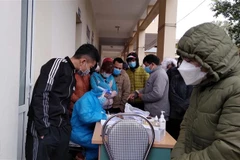 Công nhân chen nhau lấy mẫu xét nghiệm tại Trạm y tế phường Bình Minh, thị xã Nghi Sơn (Thanh Hóa). (Ảnh: Nguyễn Nam/TTXVN)