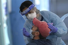 Nhân viên y tế lấy mẫu xét nghiệm người nhiễm COVID-19 tại Sydney, Australia. (Ảnh: AFP/TTXVN)