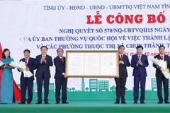 Chủ tịch Quốc hội Vương Đình Huệ trao Nghị quyết của Ủy ban Thường vụ Quốc hội về việc thành lập thị xã Chơn Thành và các phường thuộc thị xã Chơn Thành, tỉnh Bình Phước. (Ảnh: Doãn Tấn/TTXVN)
