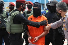 Cảnh sát áp giải nghi phạm Aris Sumarsono tại sân bay quốc tế Soekarno-Hatta ở Tangerang, Indonesia tháng 12/2020. (Nguồn: AP)