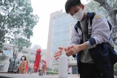 Học sinh lớp 12 trường THPT Kim Liên, quận Đống Đa thực hiện sát khuẩn tay khi tới trường học trực tiếp từ sáng 4/1/2022. (Ảnh: Thanh Tùng/TTXVN)