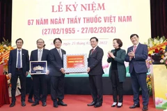 Chủ tịch Quốc hội Vương Đình Huệ tặng quà chúc mừng Bệnh viện Hữu nghị Việt Đức. (Ảnh: Doãn Tấn/TTXVN)