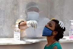 Nhân viên y tế lấy mẫu xét nghiệm COVID-19 cho người dân tại Hyderabad, Ấn Độ. (Ảnh: THX/TTXVN)