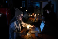 Người dân tới quán càphê ở Lviv, khi nhiều hộ gia đình đang phải chịu cảnh cắt điện luân phiên ngày 24/11/2022. (Ảnh: AFP/TTXVN)