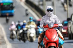 Người tham gia giao thông cần trang bị khẩu trang, áo chống nắng che kín người tránh tình trạng sốc nhiệt vì nắng nóng. (Ảnh: Thành Đạt/TTXVN)