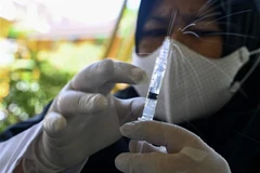 Nhân viên y tế chuẩn bị tiêm vaccine ngừa COVID-19 cho học sinh một trường tiểu học ở Banda Aceh, Indonesia, ngày 9/2/2022. (Ảnh: AFP/TTXVN)
