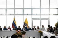 Các thành viên phái đoàn Chính phủ Colombia (phải) và nhóm vũ trang Quân đội Giải phóng Quốc gia (ELN - trái) tại cuộc họp báo sau vòng đàm phán hòa bình ở Caracas, Venezuela, ngày 21/11/2022. (Ảnh: AFP/TTXVN)