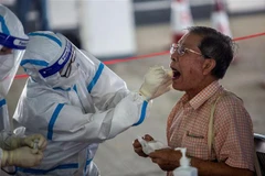 Nhân viên y tế lấy mẫu xét nghiệm COVID-19 cho người dân tại Hong Kong, Trung Quốc. (Ảnh: AFP/TTXVN)