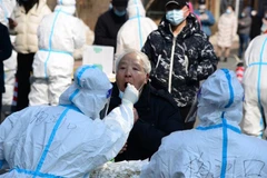 Nhân viên y tế lấy mẫu xét nghiệm COVID-19 cho người dân tại Trường Xuân, tỉnh Cát Lâm, Trung Quốc, ngày 21/3/2022. (Ảnh: THX/TTXVN)