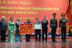 Ông Võ Văn Thưởng, Ủy viên Bộ Chính trị, Thường trực Ban bí thư (thứ 3 từ phải sang) trao Quyết định phong tặng danh hiệu Anh hùng Lực lượng vũ trang nhân dân cho Ban liên lạc Ban Tài mậu Khu ủy Khu V. (Ảnh: Quốc Dũng/TTXVN)