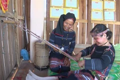 Nghệ nhân Đinh Thị Hiền hướng dẫn học viên dệt thổ cẩm. (Ảnh: Hoài Nam/TTXVN)