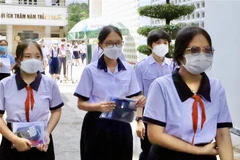 Những thí sinh đầu tiên rời khỏi phòng thi tại điểm thi Trường Trung học Phổ thông Bùi Thị Xuân (quận 3). (Ảnh: Hồng Giang/TTXVN)