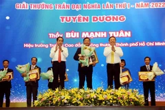 Trao bằng khen, biểu trưng và hoa cho các cán bộ quản lý, nhà giáo tiêu biểu được vinh danh giải thưởng Trần Đại Nghĩa lần thứ I năm 2022. (Ảnh: Thanh Vũ/TTXVN)