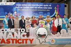 Lãnh đạo Sở Du lịch thành phố Đà Nẵng và Công ty Cổ phần Đầu tư và Khai thác ga quốc tế AHT tặng hoa, quà chúc mừng những vị khách đầu tiên trên đường bay trực tiếp mới mở lại đến Đà Nẵng của hãng hàng không Korean Air. (Ảnh: Trần Lê Lâm/TTXVN)