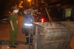 Công nhân môi trường trao đổi thông tin an ninh trật tự với lực lượng Công an. (Ảnh: Trịnh Duy Hưng/TTXVN)