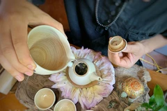 Thưởng thức một ấm trà sen sớm mai. (Ảnh: Xuân Mai/Vietnam+)