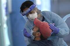 Nhân viên y tế lấy mẫu xét nghiệm COVID-19 cho người dân tại Sydney, Australia ngày 17/7/2021. (Ảnh: AFP/TTXVN)