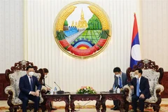 Tổng Bí thư - Chủ tịch nước Lào Thongloun Sisulith tiếp Bí thư Thành ủy Hà Nội Đinh Tiến Dũng. (Ảnh: Phạm Kiên/TTXVN)