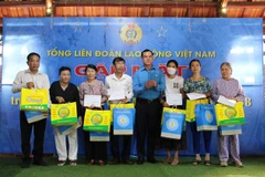 Ông Nguyễn Đình Khang, Chủ tịch Tổng liên đoàn Lao động Việt Nam trao quà và 5 triệu tiền mặt cho thân nhân các liệt sĩ đã hy sinh tại trận chiến đấu bảo vệ đảo Gạc Ma tại huyện Cam Lâm. (Ảnh: Phan Sáu/TTXVN)