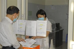 Ông Khúc Hồng Minh, tổ 10 phường Thạch Bàn đến Trạm Y tế phường xin giấy xác nhận nghỉ ốm để hưởng chế độ bảo hiểm xã hội. (Ảnh: Mạnh Khánh/TTXVN)