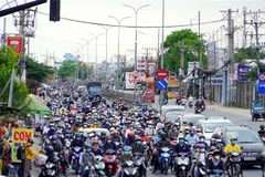 Người dân từ miền Tây về Thành phố Hồ Chí Minh rất đông, khiến Quốc lộ 1 đoạn qua cầu Bình Điền di chuyển khó khăn. (Ảnh: Tiến Lực/TTXVN)